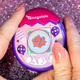 A photo of a person holding the Tamagotchi Pix Party